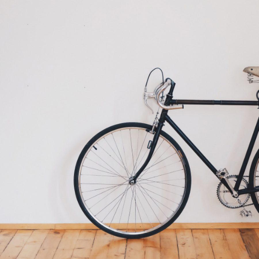 een fiets leunend tegen een witte muur in een kantoorgang