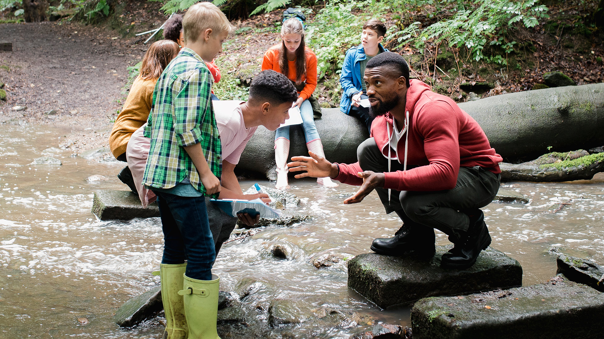 Picture at a brook in the forest, one sees children and an educator, who explains to them something, in addition the lettering "What look in the future conferences? We have suggestions!"