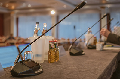 Table microphone units distributed on a conference table, with gooseneck microphones