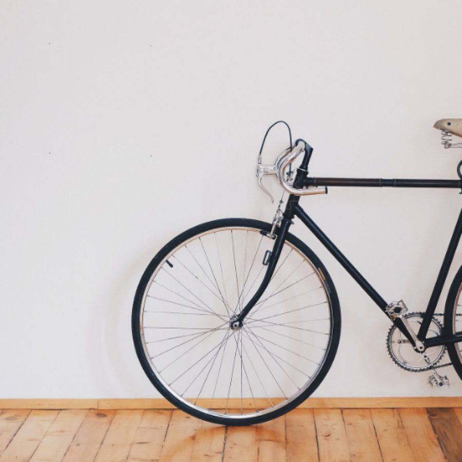 ein Fahrrad lehnt in einem Bürogang an einer weißen Wand